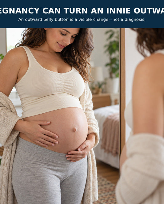 A pregnant woman looks at an outward belly button that changed from an innie during pregnancy.
